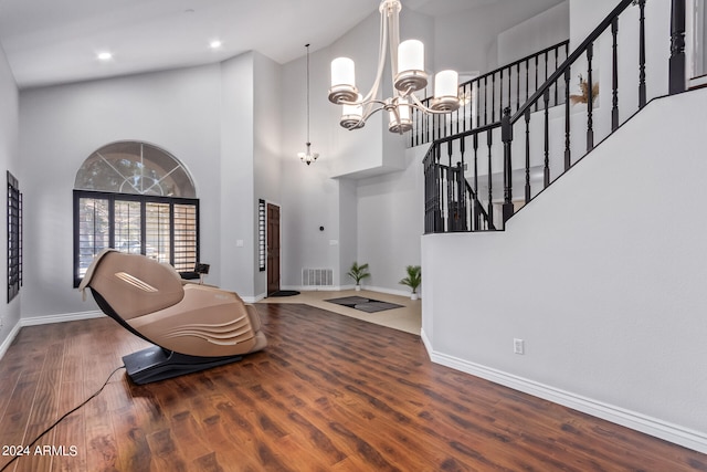 living area with a chandelier, a high ceiling, and dark hardwood / wood-style flooring