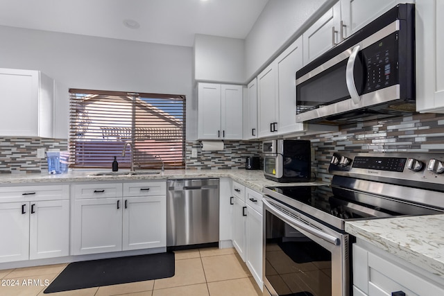 kitchen with appliances with stainless steel finishes, white cabinetry, and sink