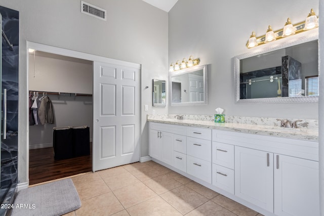 bathroom with vanity, a high ceiling, and tile patterned floors