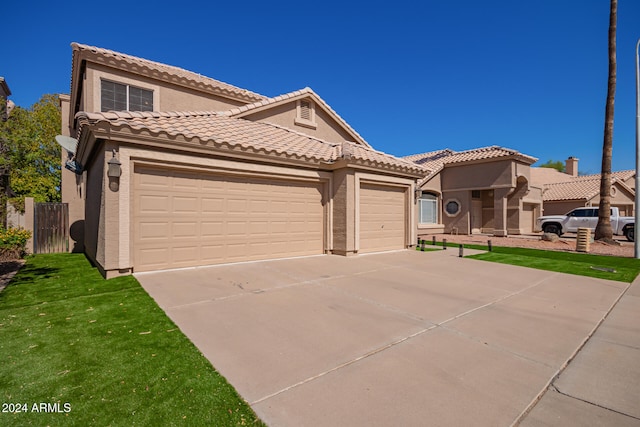 mediterranean / spanish-style house featuring a garage and a front yard