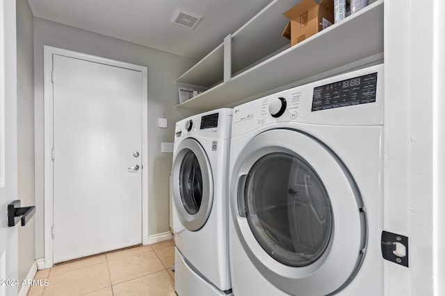 washroom with washing machine and dryer and light tile patterned floors