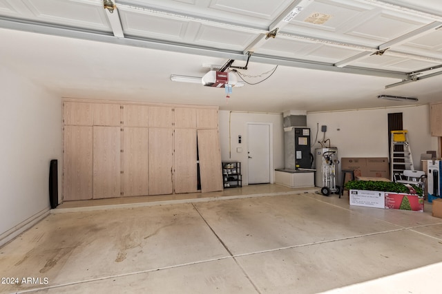 garage with a garage door opener, heating unit, and water heater