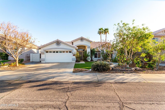 mediterranean / spanish-style house featuring a garage, a tile roof, driveway, and stucco siding