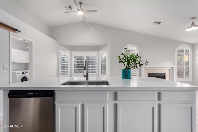 kitchen featuring visible vents, open floor plan, dishwasher, a barn door, and a sink