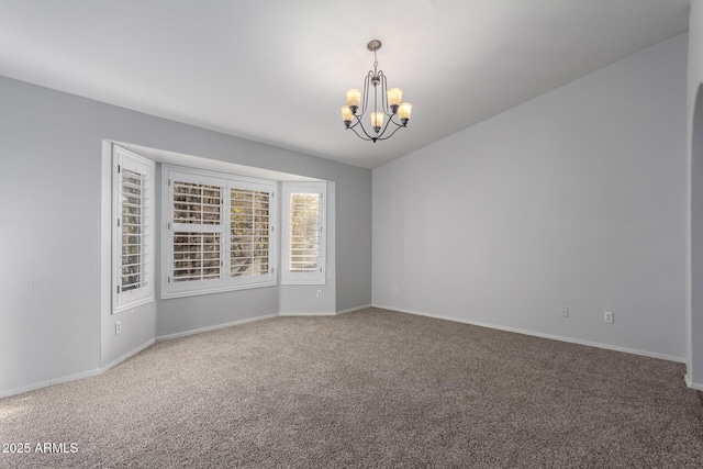 spare room featuring a notable chandelier, carpet, and baseboards