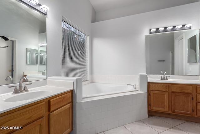 bathroom with a sink, two vanities, a bath, and tile patterned floors