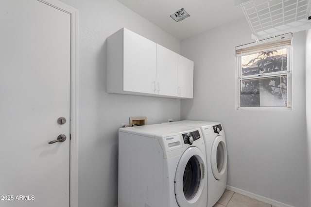 laundry room featuring washer and dryer, baseboards, cabinet space, and light tile patterned floors