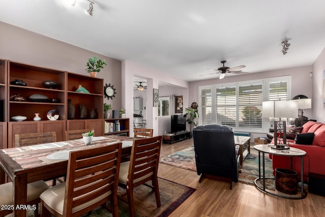 dining area with rail lighting, light wood-style floors, and a ceiling fan