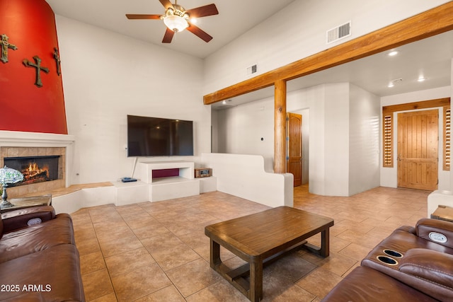 living area with a tile fireplace, visible vents, recessed lighting, and ceiling fan