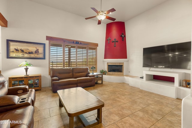 tiled living room featuring high vaulted ceiling, a high end fireplace, and ceiling fan