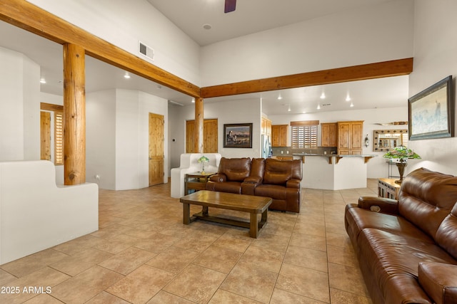living area featuring a high ceiling, a ceiling fan, visible vents, and recessed lighting