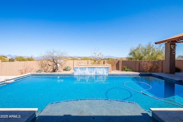 view of pool with a fenced backyard, a fenced in pool, and a mountain view