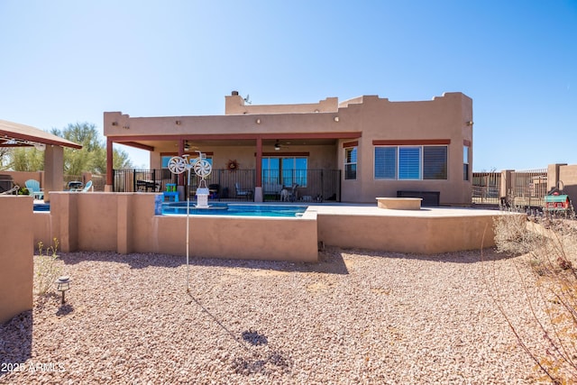 rear view of house featuring fence, ceiling fan, a patio area, and stucco siding