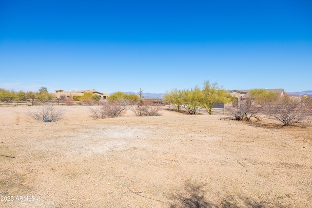 view of yard featuring fence and a rural view