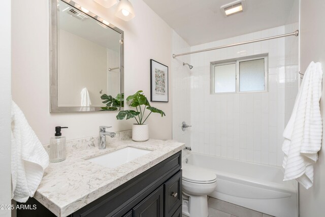 full bathroom featuring toilet, tiled shower / bath, and vanity