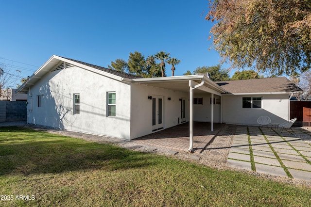 rear view of property with a patio and a lawn