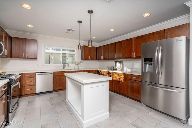 kitchen featuring appliances with stainless steel finishes, hanging light fixtures, a center island, ornamental molding, and sink