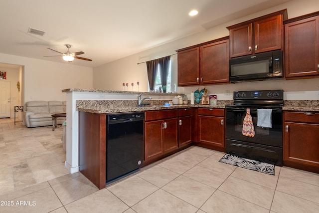 24349 W Gregory Rd, Buckeye, AZ 85326 - kitchen with a peninsula, visible vents, ceiling fan, light stone countertops, and black appliances