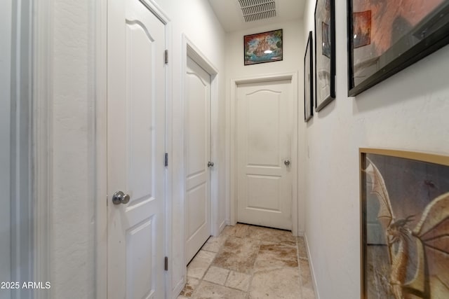 24349 W Gregory Rd, Buckeye, AZ 85326 - doorway to outside featuring stone finish floor, visible vents, and baseboards