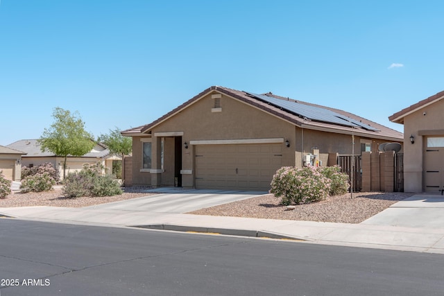 24349 W Gregory Rd, Buckeye, AZ 85326 - ranch-style house with a gate, solar panels, an attached garage, stucco siding, and driveway