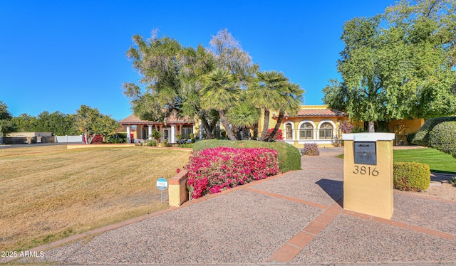 mediterranean / spanish-style home featuring a front yard