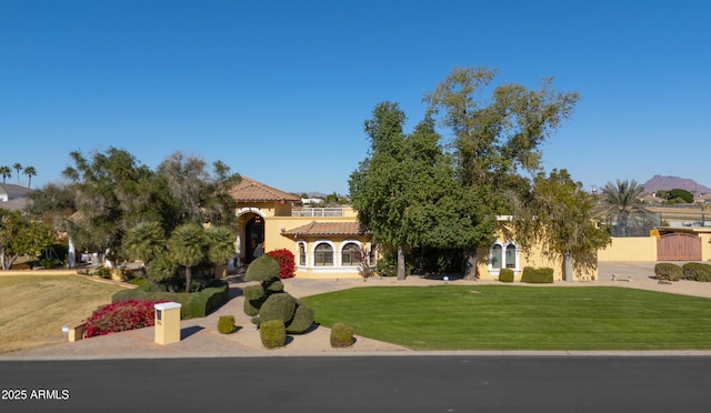 mediterranean / spanish home featuring a mountain view and a front lawn