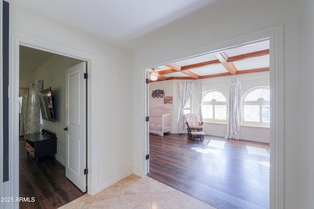 hallway featuring light wood-type flooring and coffered ceiling