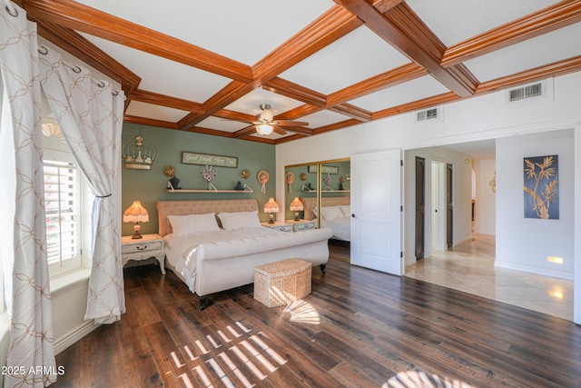 bedroom with ceiling fan, beam ceiling, dark wood-type flooring, and coffered ceiling