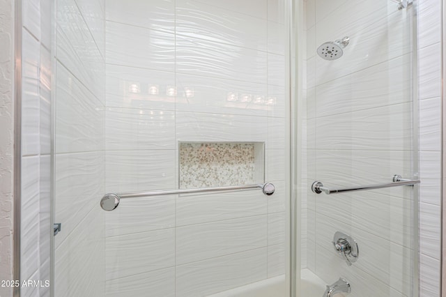 bathroom with bath / shower combo with glass door