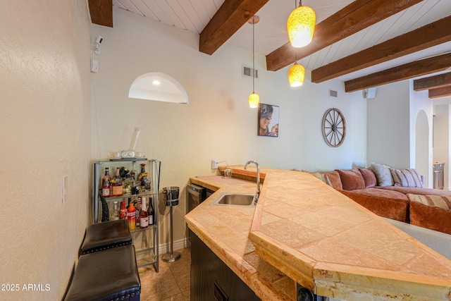 kitchen featuring wooden ceiling, decorative light fixtures, sink, and beamed ceiling