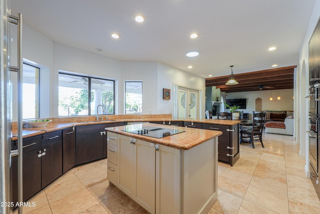 kitchen featuring ceiling fan, black electric cooktop, a kitchen island, dark brown cabinetry, and sink