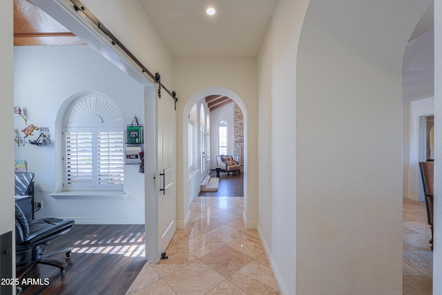 corridor with a healthy amount of sunlight and a barn door