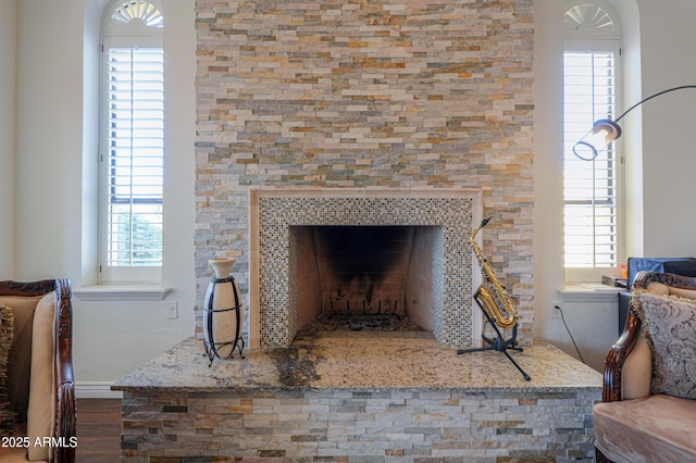 interior details featuring hardwood / wood-style flooring and a tiled fireplace