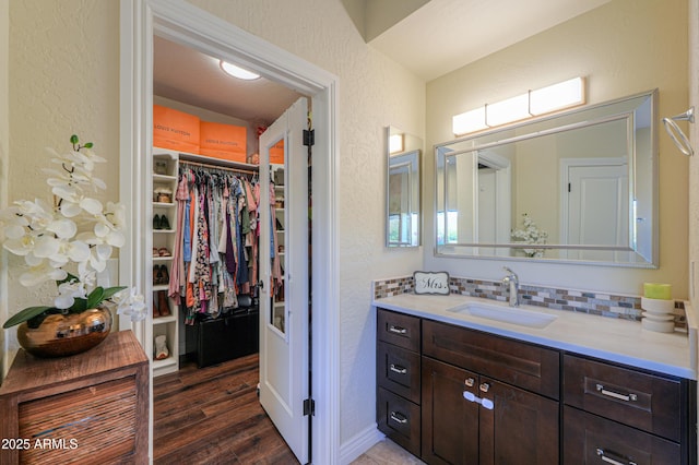 bathroom with wood-type flooring, backsplash, and vanity