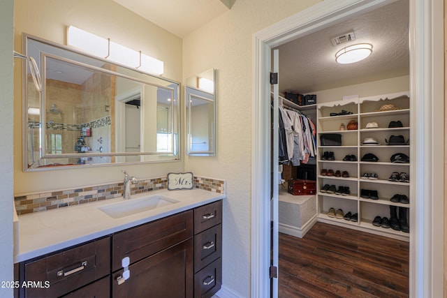 bathroom featuring vanity, decorative backsplash, a textured ceiling, and hardwood / wood-style flooring