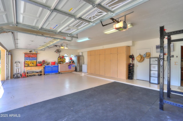 garage featuring stainless steel fridge and a garage door opener