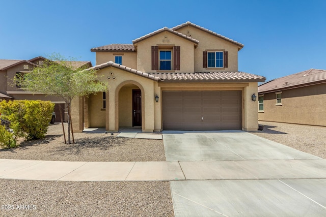 mediterranean / spanish-style home with a garage, driveway, a tiled roof, and stucco siding