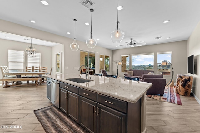 kitchen with sink, dishwasher, decorative light fixtures, and light stone countertops