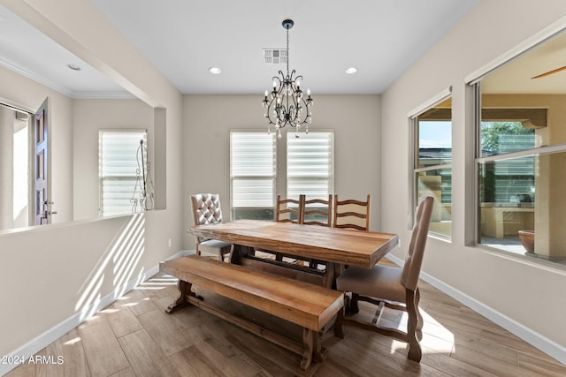 dining space with wood-type flooring and an inviting chandelier