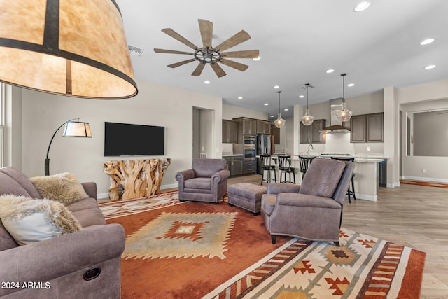 living room featuring light hardwood / wood-style flooring and ceiling fan