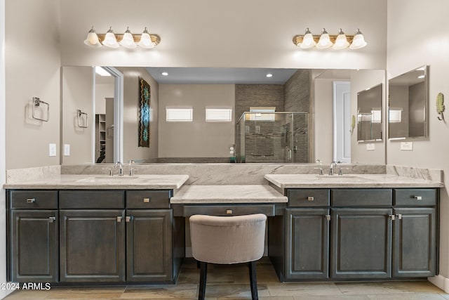 bathroom featuring tile patterned flooring, a tile shower, and vanity