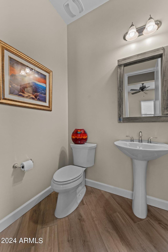 bathroom with ceiling fan, toilet, and wood-type flooring