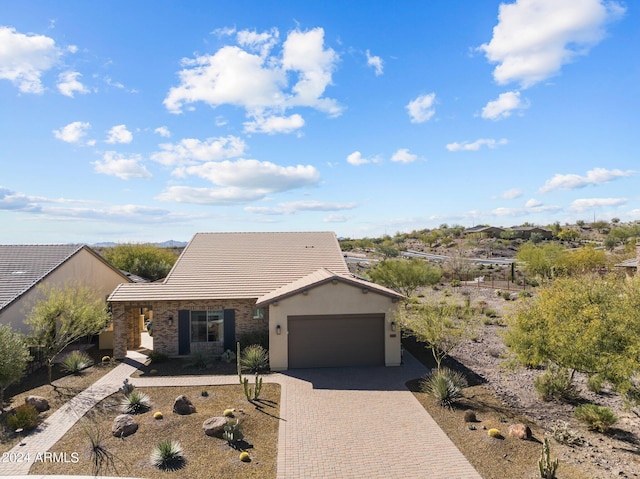 view of front facade with stone siding, stucco siding, decorative driveway, and a garage