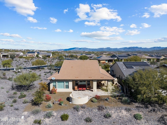 exterior space with a mountain view, a patio, stucco siding, and a tile roof