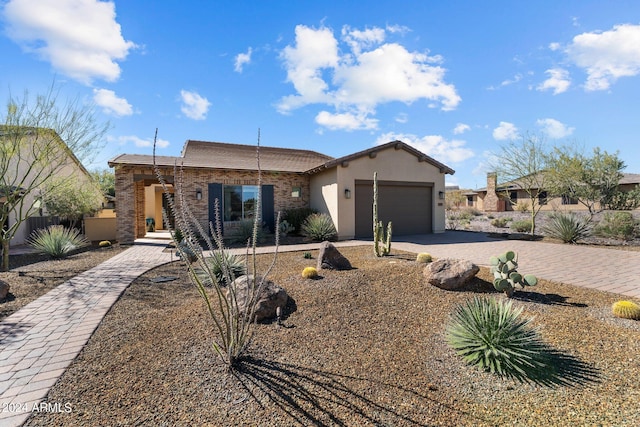 view of front of home with stucco siding, decorative driveway, and a garage