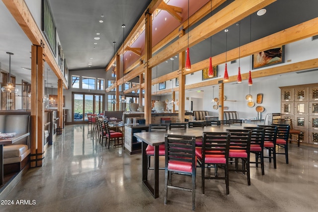 dining room with a high ceiling and finished concrete flooring