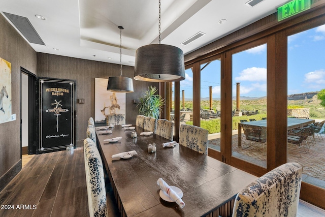 dining room with a tray ceiling, plenty of natural light, french doors, and wood-type flooring