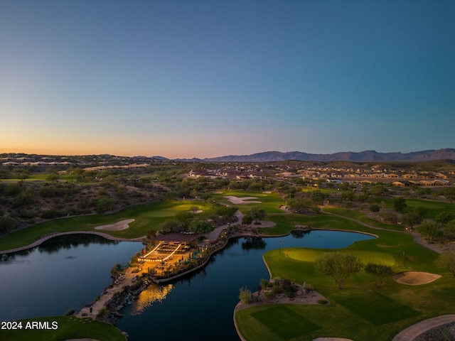 aerial view at dusk featuring a water and mountain view