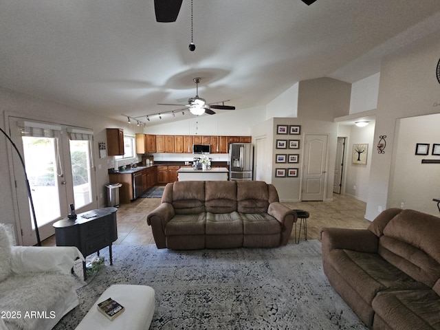 living room featuring lofted ceiling, ceiling fan, and light tile patterned flooring