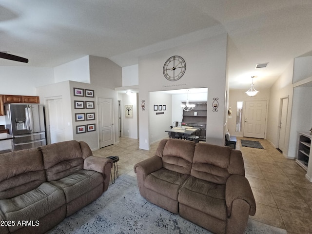 tiled living room featuring a notable chandelier and high vaulted ceiling